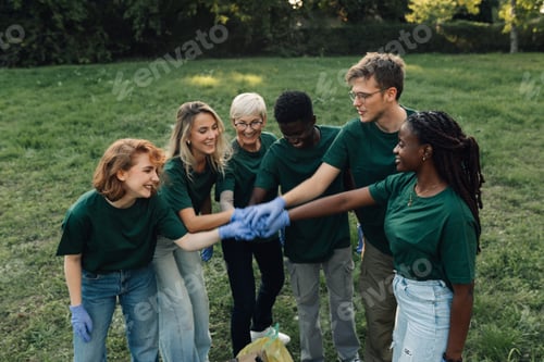 Preview: Group of volunteers putting hands together showing teamwork for cleaning park