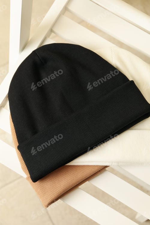 Preview: Three stylish beanies on wooden chair, top view