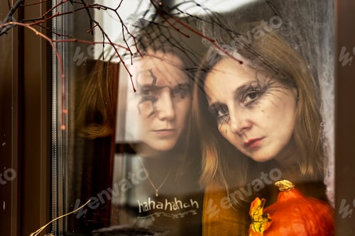 Preview: Two witches look through of the window of Halloween decorations. Masquerade, Halloween party