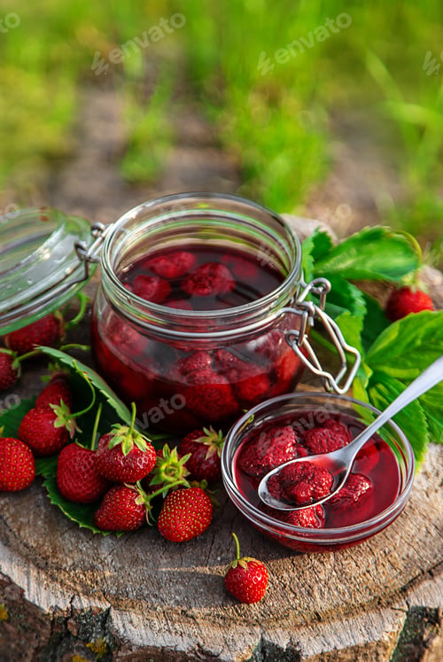 Preview: Strawberry jam in the garden. Selective focus.