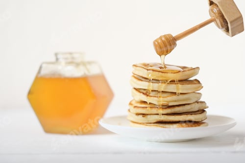 Preview: Stack of homemade Pancakes with pouring honey. organic natural ingredients concept.
