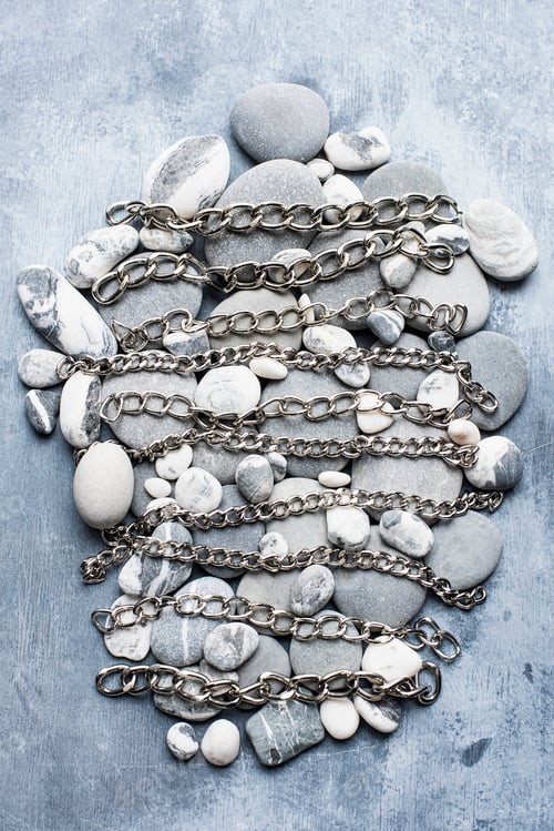 Preview: Chains and pebbles arranged in a pattern on a textured blue background