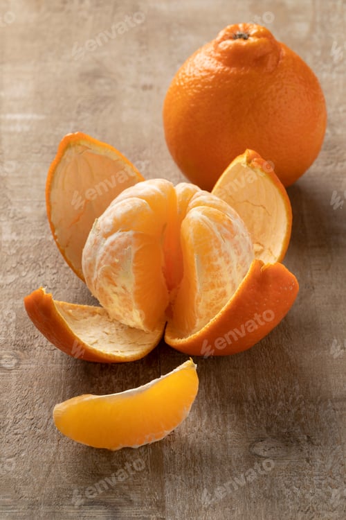 Preview: Fresh tangelos and a peeled one close up