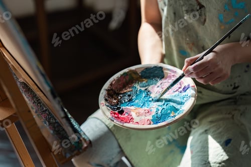 Preview: Close-up of a Person Painting on Canvas with a Palette of Vibrant Colors, Showcasing the Artistic