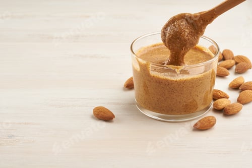 Almond Butter Dripping from Spoon into Glass