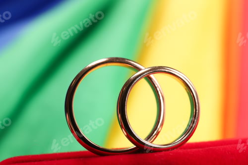 Preview: Wedding rings on rainbow LGBT flag, closeup