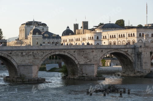 Preview: Beautiful shot of a stony bridge with three arches and some buildings with gray roofs