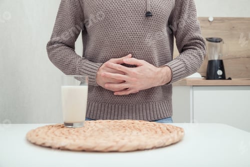 Preview: Man feels bad, lactose intolerance. Dairy intolerant person. Health care concept and milk