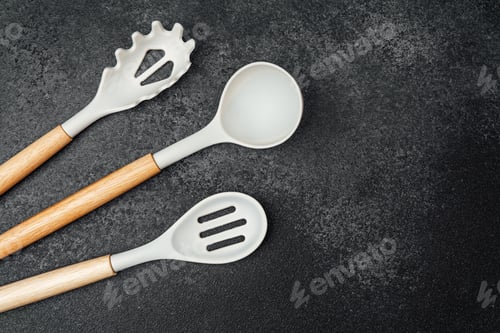 Preview: Kitchen utensils arranged on a dark stone surface for culinary use