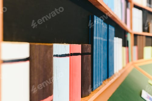 Preview: Colorful books on wooden shelf in library setting