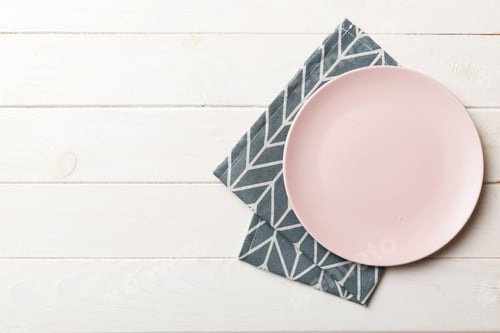 Preview: Top view on colored background empty round pink plate on tablecloth for food