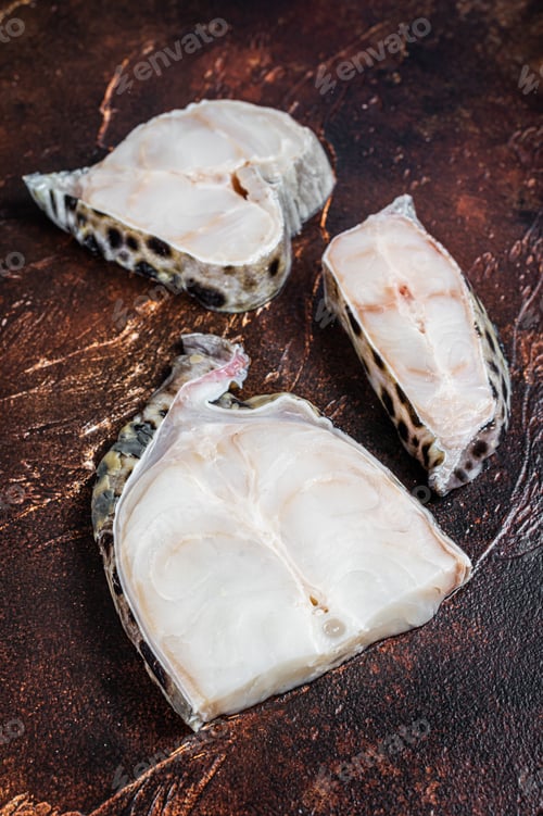 Preview: Raw atlantic wolffish fish Steak. Dark background. Top view