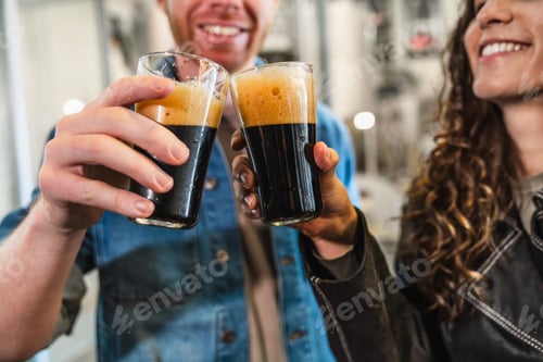 Vista previa: Pareja celebrando brindando por jarras de cerveza robustas
