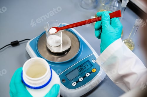 Preview: A woman chemist measures powder samples with laboratory balances.