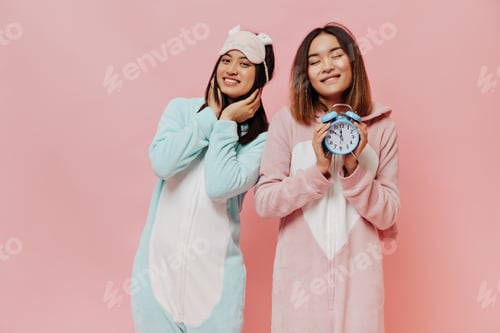 Preview: Pretty brunette Asian girls in sleep wears smile sincerely. Young women in white pajamas pose on pi
