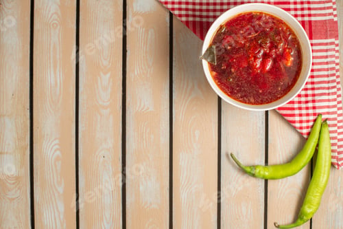 Preview: top view red vegetable borsh inside white plate laong with green peppers on the wooden desk food