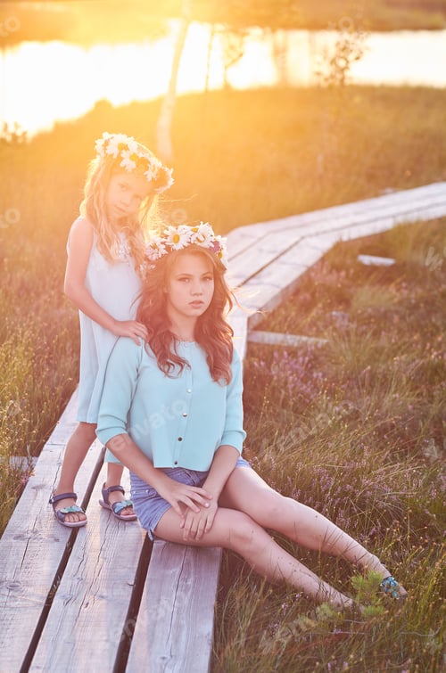 Preview: Two girls posing on the wooden road in a field.