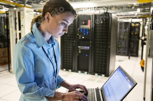 Preview: Caucasian woman technician running diagnostics on computer servers in a server farm.