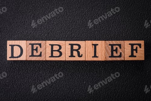 Preview: The inscription debrief in wooden cubes on a dark concrete background