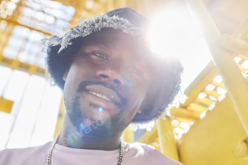 Vista previa: Close up young African American man looking at camera urban with lens flare