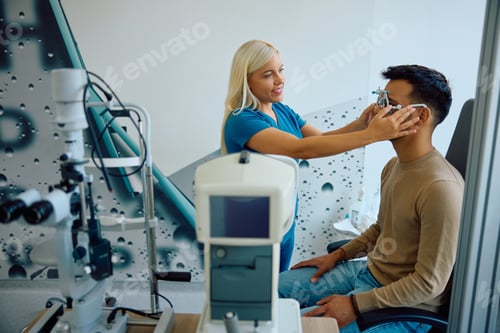 Preview: Happy ophthalmologist using testing eyeglasses during eye exam of her patient at the clinic.