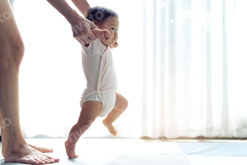 Preview: Asian baby taking first steps walk forward on the soft mat.