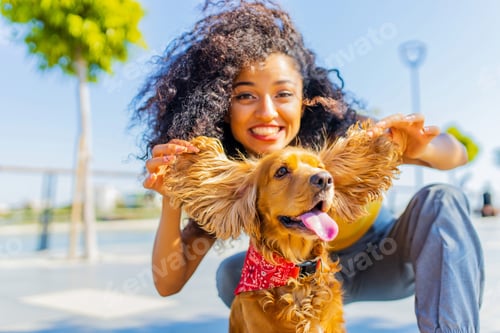 Preview: young happy curls hair woman playing with american cocker on the beach alley in sun light palms