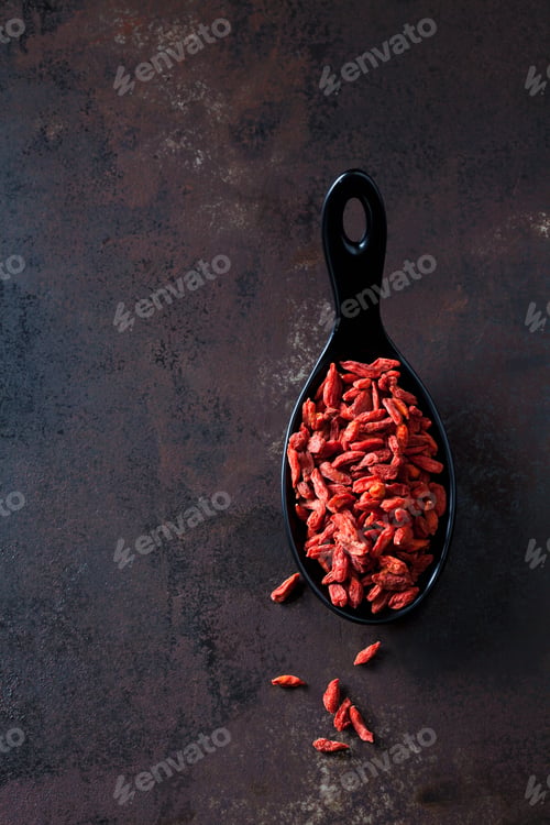Preview: Spoon of dried wolfberries on rusty metal