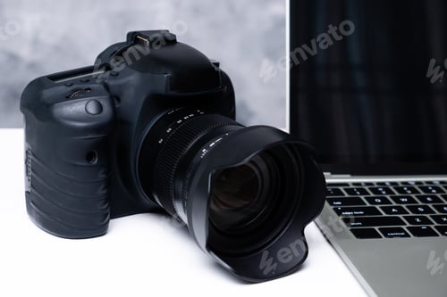 Preview: A black digital camera and a computer laptop on a table