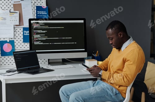 Preview: African American developer using smartphone at office