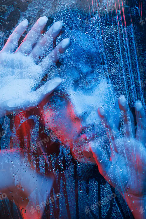 Preview: Studio shot in dark studio with neon light. Portrait of beautiful girl behind wet glass