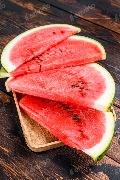 Preview: Heap of fresh red sliced watermelon. Dark Wooden background. Top view