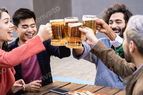 Preview: Multiracial friends having fun chearing with beers at brewery bar restaurant outdoor - Focus on