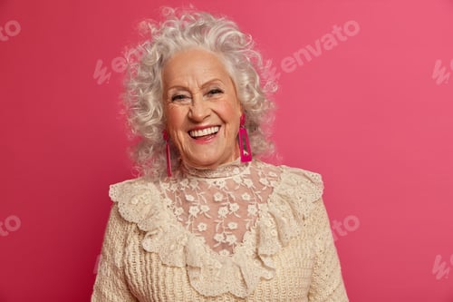Preview: Vivacious wrinkled woman with curly hair smiles positively glad receive congratulations from childre