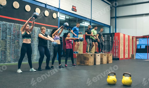 Preview: Sportswomen with kettlebells and sportsmen in background