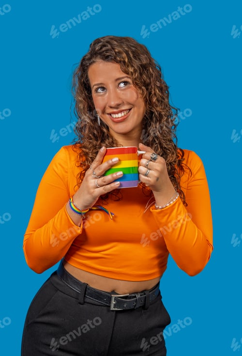 Preview: Young woman holding rainbow mug and smiling, celebrating diversity and inclusion