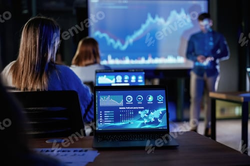 Preview: In dark room. Male business trainer is against projector with data, teaching people