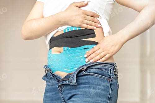 Preview: A woman glues a medical tape for burningRelaxation and reduction of pain, cramps during menstruation