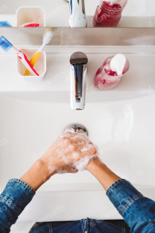 Preview: unrecognizable woman washing hands on a sink with soap. Coronavirus covid-19 concept