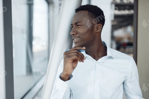 Preview: Black businessman poses in office building