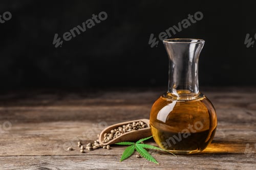 Preview: Composition with hemp oil on wooden table. Space for text