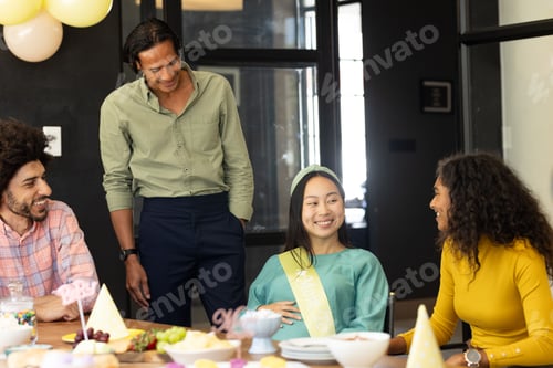 Preview: Diverse group celebrating baby shower at office, smiling and enjoying conversation