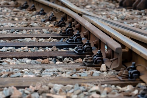 Rusty Railroad Tracks Diverge with Gravel