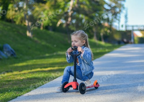 Preview: Little girl is riding a scooter
