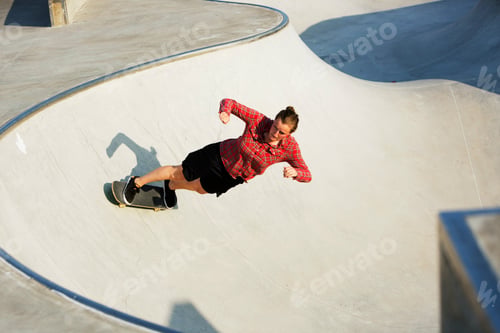 Preview: High angle view of woman skateboarding on ramp in skate park