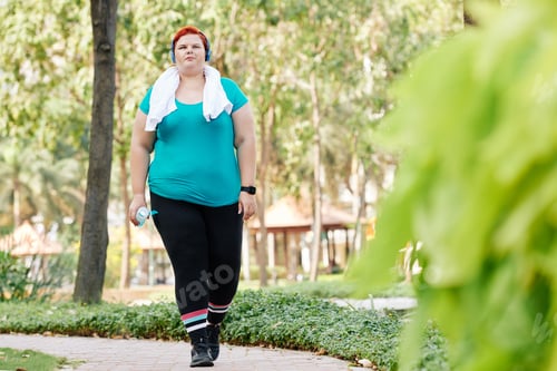 Preview: Overweight woman walking in park