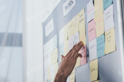 Preview: cropped view of businessman touching sticky notes with letters in office