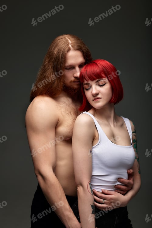 Preview: Happy sexy passionate young couple in love hugging in studio. Handsome muscular half-naked man and