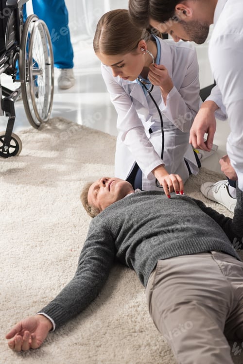 Preview: female doctor checking unconscious middle aged man palpitation with stethoscope