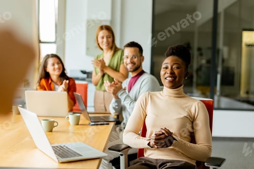 Preview: Cute Africam American woman with her young multiethnic startup team working in the modern office